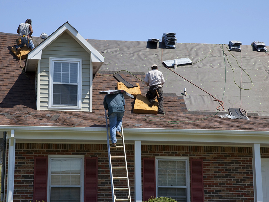 Three males on a roof making repairs